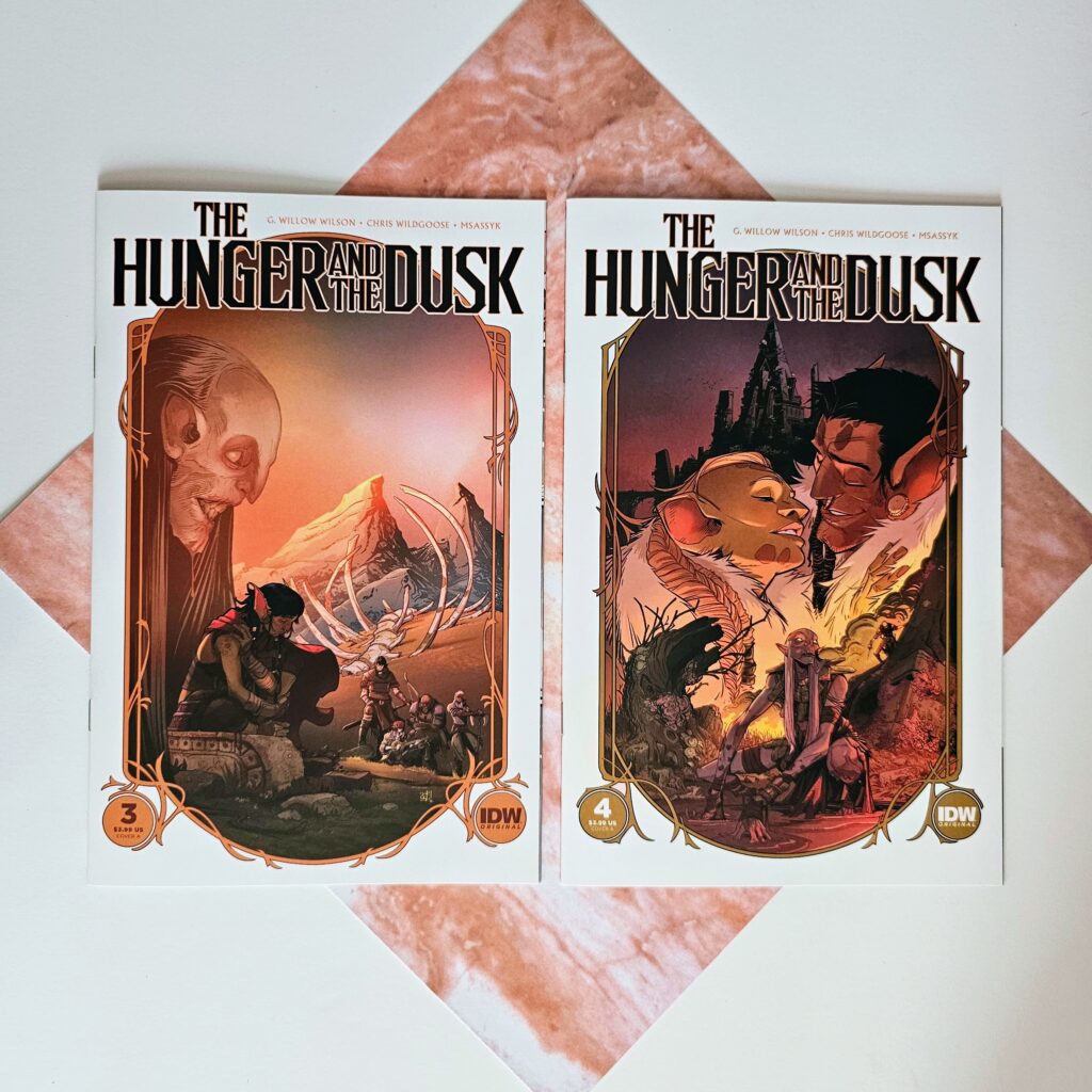 Issues 3 and 4 of The Hunger and The Dusk laying on a square piece of paper that looks like pink marble.